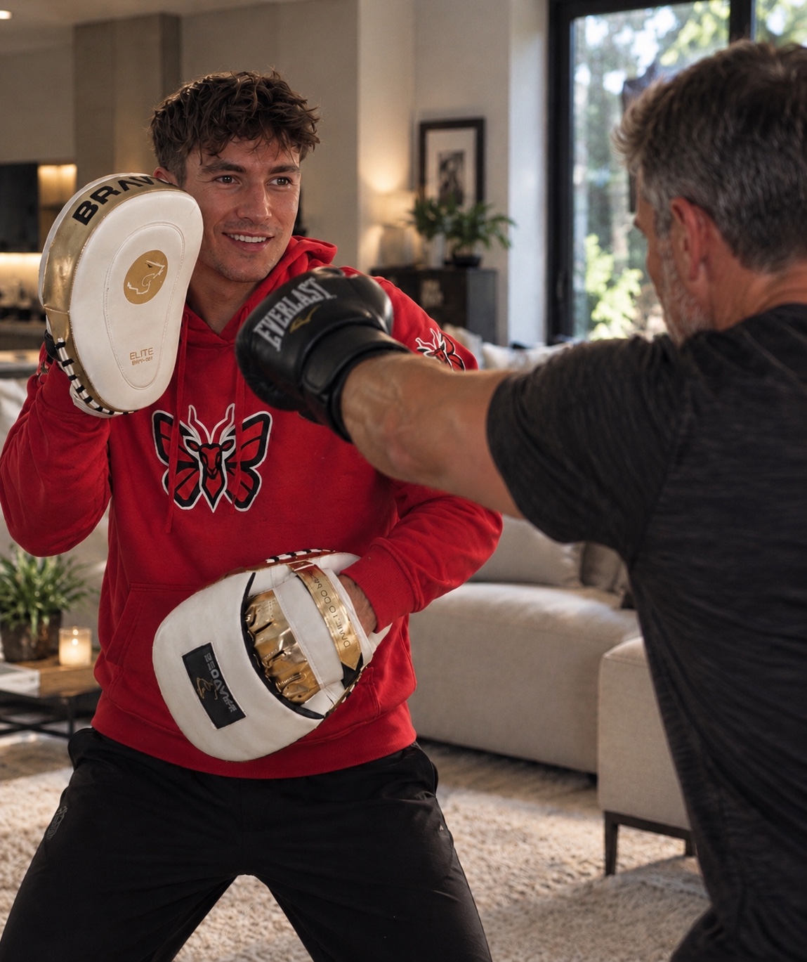 Reece coaching a client on boxing pads during an at-home session